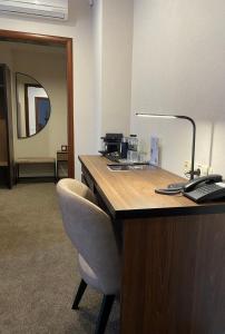 an office with a desk with a chair and a lamp at Grand Christer Hotel in Kyiv