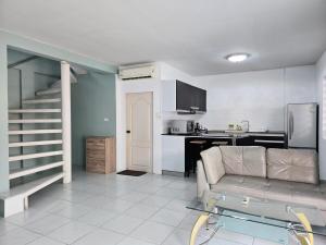 a living room with a couch and a kitchen at Townhome 44 in Ban Nong Pru