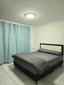 a bedroom with a large bed with blue curtains at Townhome 44 in Ban Nong Pru