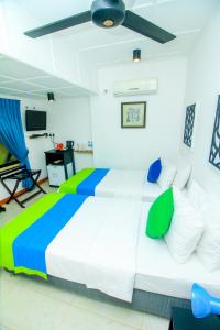 康提Settle Inn Tourist Lodge的卧室配有带绿色和蓝色枕头的大型白色床 更多163张照片