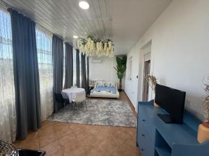 a living room with a blue dresser and a table at Nadya Holiday Home in Karianí