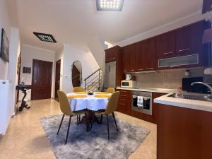 a kitchen with a table and chairs in a room at Nadya Holiday Home in Karianí
