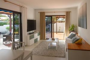 a living room with a couch and a tv at Niteo House in Costa Teguise