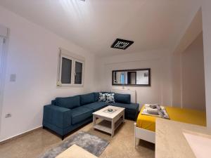 a living room with a blue couch and a table at Nadya Holiday Home in Karianí
