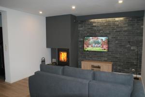 a living room with a blue couch and a brick wall at Kwiatowe Zacisze in Szczyrk