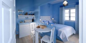 a blue bedroom with a bed and a table at Santorini Roses Suites in Imerovigli +72 photos