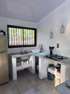 a kitchen with a counter and a sink and a refrigerator at Las cabañas in Jacó