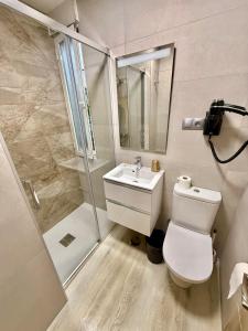 a bathroom with a toilet and a shower and a sink at Hostal Fernández Atocha in Madrid