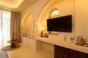 a hotel room with a flat screen tv on a wall at Iconic Mediterranean Hotel in Dhërmi