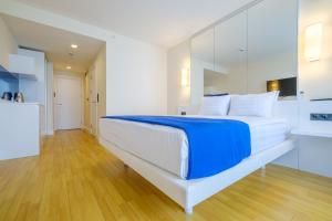 a bedroom with a large white bed with blue sheets at Orbi City Collection in Batumi