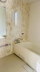 a white bath tub in a bathroom with a window at 街角TheStreetCorner in Noritake-Shinmachi