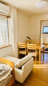 a room with a table and a couch and a dining room at 街角TheStreetCorner in Noritake-Shinmachi