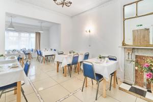 a dining room with tables and chairs and a fireplace at Park Hotel in Ilford
