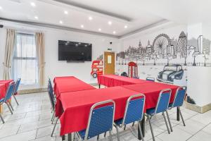 a dining room with red tables and blue chairs at Park Hotel in Ilford