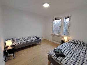 two beds in a room with two windows at Workers Stay - Temporary House Gothenburg in Gothenburg