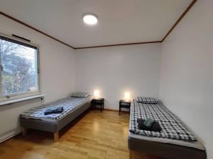 two beds in a room with two windows at Workers Stay - Temporary House Gothenburg in Gothenburg