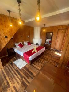 a bedroom with a large bed in a room with wooden floors at Redwood inn homestay in Nuwara Eliya