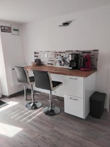 a kitchen with a counter with two chairs and a table at Ty Menic in Lesneven