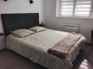 a bedroom with a bed with a blanket on it at Ty Menic in Lesneven