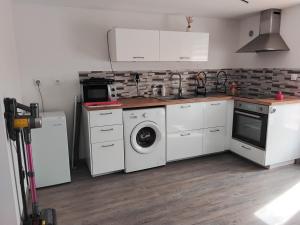 a kitchen with a washing machine and a washer at Ty Menic in Lesneven