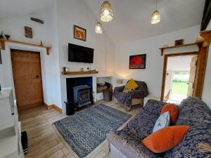 a living room with a couch and a fireplace at Rose Cottage Solway Self Catering in Cardurnock