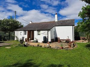 a small white house with a yard at Rose Cottage Solway Self Catering in Cardurnock