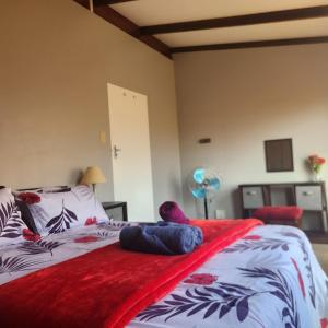 a bedroom with a bed with a red blanket on it at 51onStirling in De Kelders