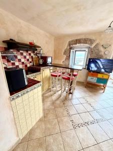 a kitchen with a counter and stools in it at Family Apartman Baška in Baška