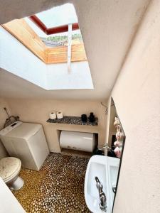 a small bathroom with a toilet and a skylight at Family Apartman Baška in Baška +23 photos