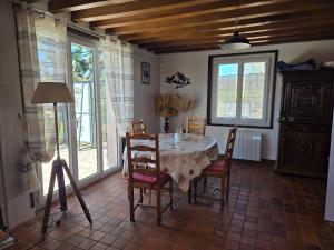 a dining room with a table and chairs and windows at Edelweiss in Moux-en-Morvan