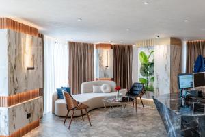 a living room with a white couch and chairs at Mattis Hotel in Tirana