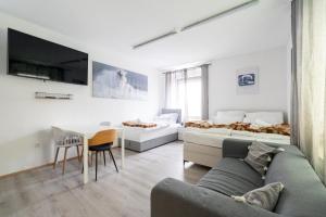 a living room with a couch and a bed at COY Apartments Leoben - Central near Uni & Station with 24 7 Check-in in Leoben