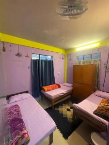 a room with three beds in a room at Hazz Backpackers Hostel in Shillong
