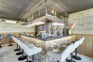 a bar with a row of white bar stools at Residence Winterswijk in Winterswijk