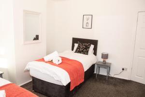 a bedroom with a bed with a stuffed animal on it at 3 Bed - Shefa Homes in Manchester