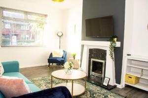 a living room with a couch and a fireplace at 3 Bed - Shefa Homes in Manchester