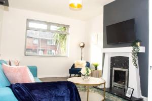 a living room with a blue couch and a fireplace at 3 Bed - Shefa Homes in Manchester +19 photos