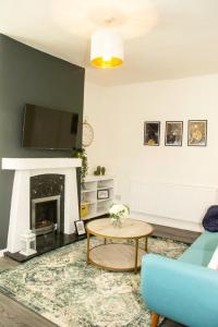 a living room with a blue couch and a fireplace at 3 Bed - Shefa Homes in Manchester
