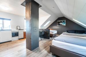 a attic bedroom with a bed and a kitchen at Guesthouse Andrea in Reykjavík