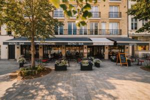 a street with tables and chairs and a building at Hotel Le Bois De Bruges in Bruges
