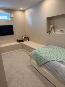 a bedroom with a bed and a flat screen tv at Workers Stay - Temporary House Stockholm in Rönninge