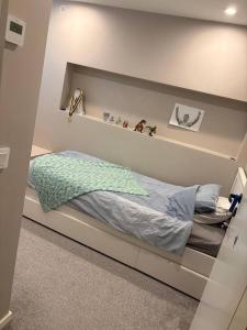 a bedroom with a bed with a shelf on the wall at Workers Stay - Temporary House Stockholm in Rönninge