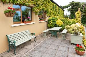 a patio with two benches and a table and flowers at The Loft in Redcross
