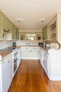 a kitchen with green cabinets and white appliances at The Loft in Redcross