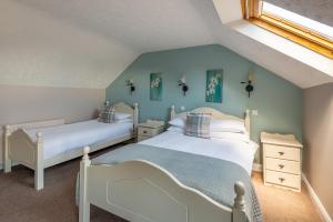 two beds in a bedroom with blue walls at The Loft in Redcross