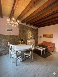 une salle à manger avec une table, des chaises et un lit dans l'établissement La Ca' Tòrta - Rustico ristrutturato, à Neviano degli Arduini