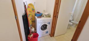 a washing machine in a bathroom with a surfboard at Best Holidays Pineta in Marcelli