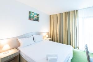 a hotel room with a white bed and a window at Complex Bran Brad Bega in Eforie Nord