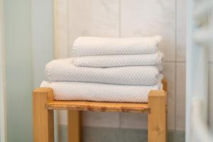 a stack of white towels on a wooden shelf at Apartments and rooms Pri Urhu in Bohinj +67 photos