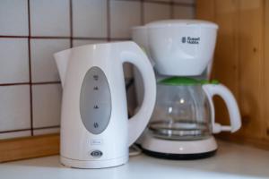 a white blender next to a white coffee maker at Apartments and rooms Pri Urhu in Bohinj